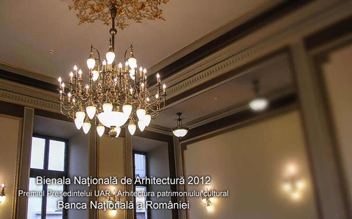 Sală de consiliu din Palatul Băncii Naționale a României, cu un candelabru mare din alamă cu abajururi opal, aplice pe pereți și o plafonieră suspendată