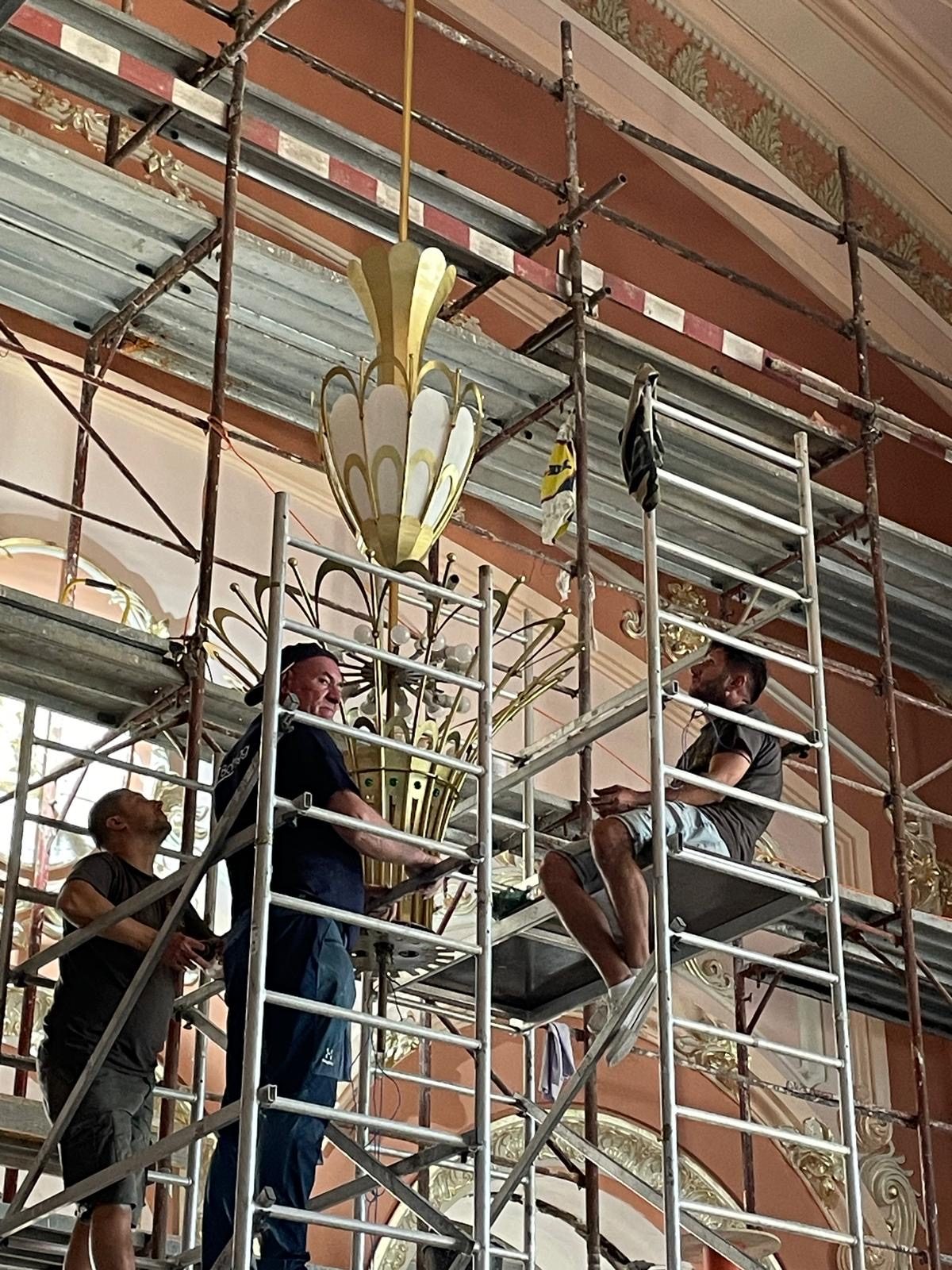Echipa pe schele, montând un candelabru în Cazinoul din Constanța