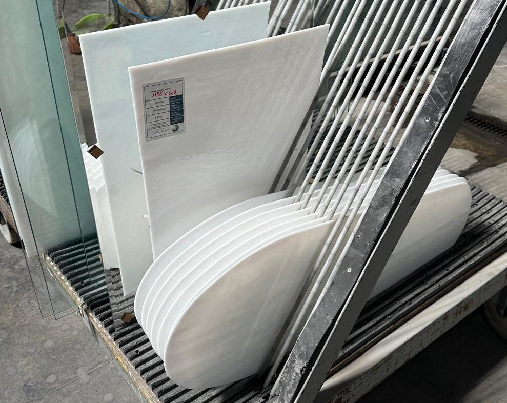 Petale de sticlă opal așezate vertical într-un rastel metalic pe roți
