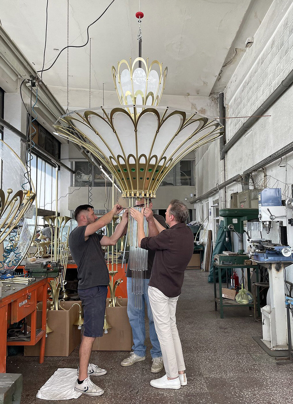 Candelabru aprins pentru prima dată, suspendat în atelier, cu echipa dedesubt