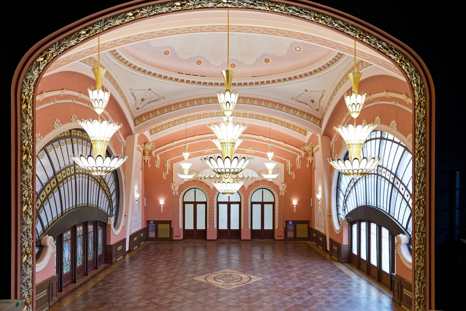 Sala mare a Cazinoului văzută prin arcada balconului, cu candelabrele aprinse