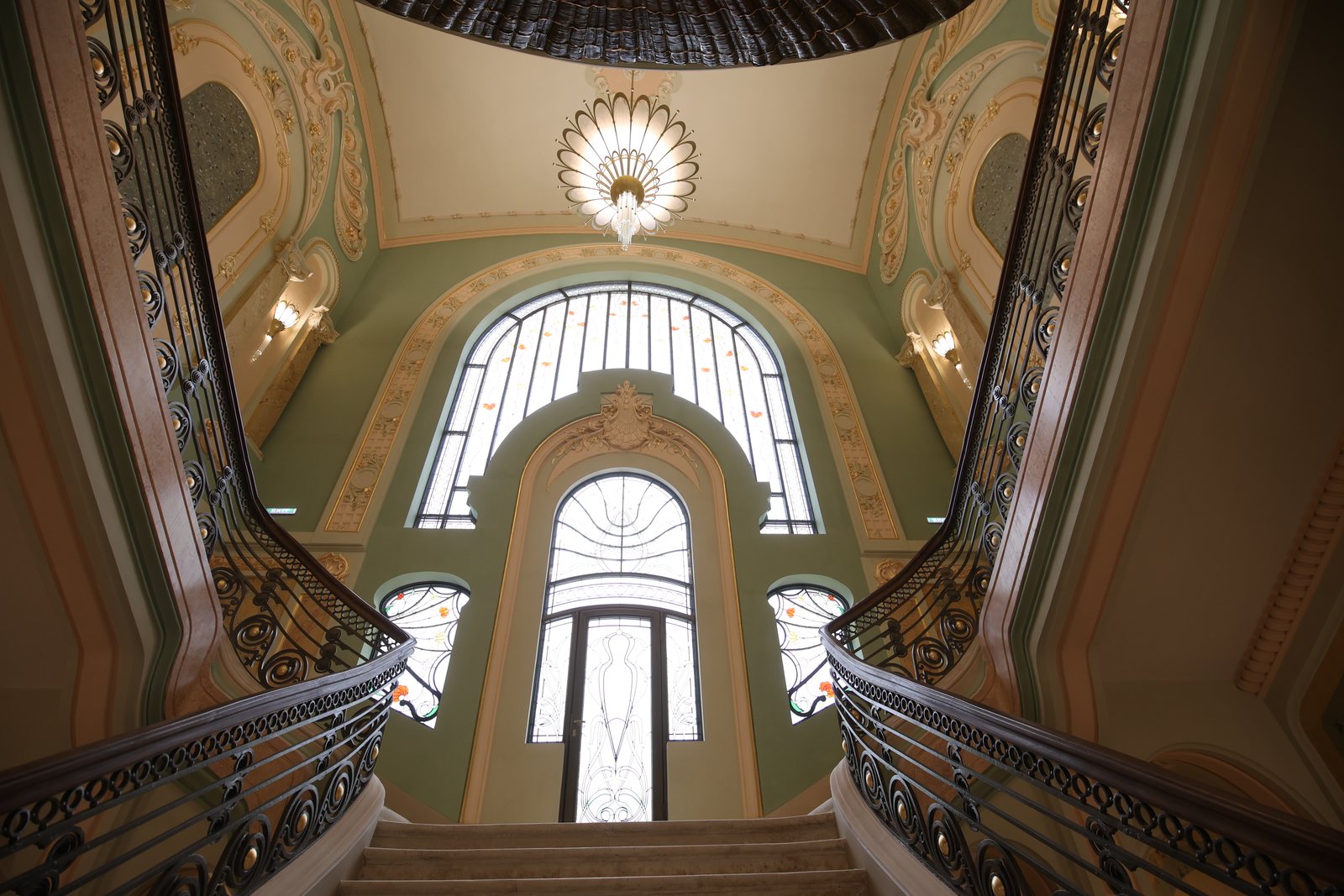 Scara de onoare a Cazinoului, cu balustrade din fier forjat, candelabru și vitraliu, văzută de jos
