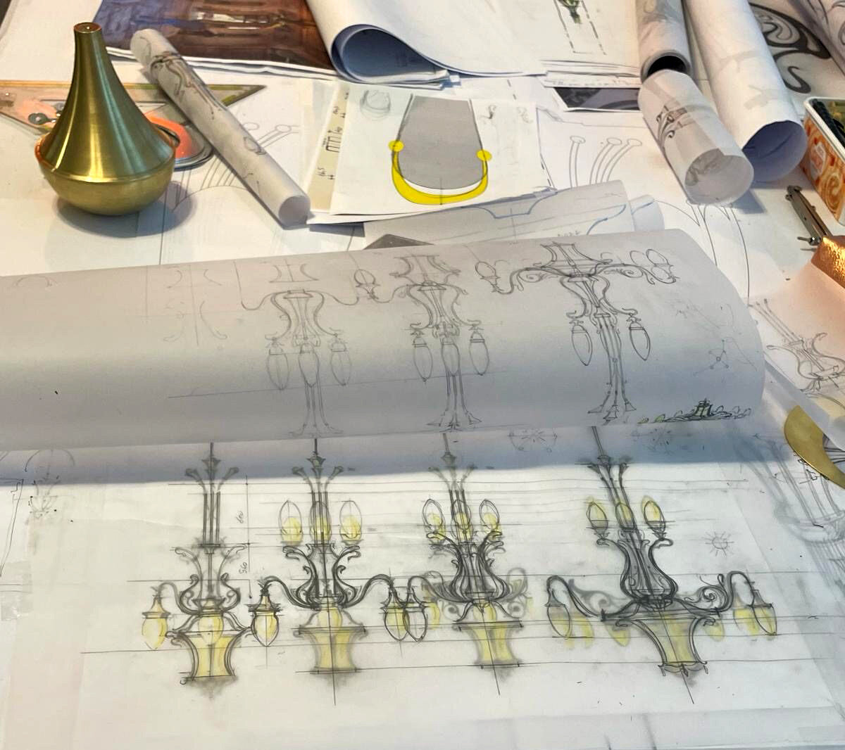 Patru schițe alternative ale unei aplice Art Nouveau pe masa de lucru