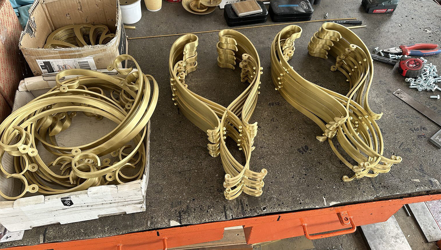 Volute de alamă stivuite pe bancul de lucru
