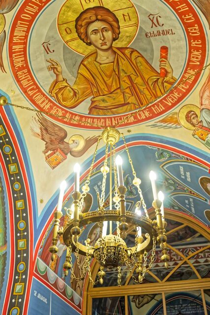 Candelabru din alamă cu șase brațe, pe fondul bolții pictate a bisericii din Săpânța